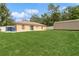 Beautiful backyard showcasing a green lawn, storage shed, and a white privacy fence at 1395 Deland Ave, Orange City, FL 32763