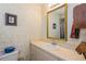 Cozy bathroom features a vanity with white countertop and decorative wall mirror at 1395 Deland Ave, Orange City, FL 32763