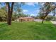 Spacious home surrounded by a lush green lawn and mature trees in a serene setting at 1395 Deland Ave, Orange City, FL 32763