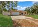 Charming single-story home featuring a spacious driveway, lush lawn, and decorative landscaping at 1395 Deland Ave, Orange City, FL 32763