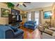 Cozy living room with a ceiling fan, comfortable seating, and natural light from the windows at 1395 Deland Ave, Orange City, FL 32763