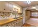 Bright kitchen featuring wood countertops, light cabinetry, and floral wallpaper at 149 E Plantation Blvd, Lake Mary, FL 32746