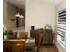 Dining room area with dark wood furniture, window with blinds, and a bar area overlooking the kitchen at 149 Southampton Dr, Kissimmee, FL 34744