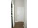Hallway leading to laundry room with white door and wood laminate floors at 149 Southampton Dr, Kissimmee, FL 34744