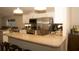 Well-lit kitchen featuring granite countertops, stainless steel appliances, white cabinets and a breakfast bar at 149 Southampton Dr, Kissimmee, FL 34744