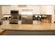 Well-lit kitchen featuring granite countertops, stainless steel appliances, and white cabinets at 149 Southampton Dr, Kissimmee, FL 34744