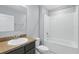 Cozy bathroom features a bathtub with a shower and a sink with granite countertops at 15250 Aquarius Way, Mascotte, FL 34753