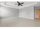 Spacious bedroom with neutral walls, tile floors, and modern ceiling fan at 15250 Aquarius Way, Mascotte, FL 34753