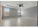 Spacious bedroom features neutral walls, tile floors, tray ceiling, and a modern ceiling fan at 15250 Aquarius Way, Mascotte, FL 34753