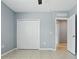 Simple bedroom with tiled floors, closet, and gray walls provide a neutral and cozy atmosphere at 15250 Aquarius Way, Mascotte, FL 34753