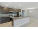 Modern kitchen with stainless steel appliances, a granite island, and dark wood cabinets at 15250 Aquarius Way, Mascotte, FL 34753
