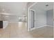 Open-concept living room featuring neutral gray walls, ceramic tile flooring, and recessed lighting at 15250 Aquarius Way, Mascotte, FL 34753