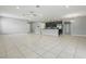 Spacious open living area with tile flooring, neutral gray walls, and a modern kitchen with stainless appliances at 15250 Aquarius Way, Mascotte, FL 34753