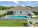Backyard featuring a swimming pool with screened in lanai and fenced surround at 15250 Aquarius Way, Mascotte, FL 34753