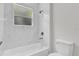 Bright bathroom with marble tile, a bathtub, shower, and a window at 15443 Sw 21St Ct, Ocala, FL 34473