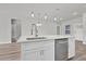 Modern kitchen island with stainless steel dishwasher, sink, and stylish pendant lights at 15443 Sw 21St Ct, Ocala, FL 34473