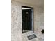 Condo entrance with dark door, welcome mat, and bench on stone-textured exterior at 155 N Pearl Lake Cswy # 104, Altamonte Springs, FL 32714