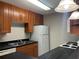 Kitchen featuring wood cabinets, white appliances, and sleek countertops at 155 N Pearl Lake Cswy # 104, Altamonte Springs, FL 32714