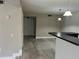 View of living space with breakfast bar, laminate floors and access to the front door at 155 N Pearl Lake Cswy # 104, Altamonte Springs, FL 32714