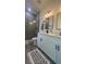 Beautiful bathroom with modern lighting, gray shower and tile, white cabinets and luxury rug at 16367 Sw 17Th Terrace Rd, Ocala, FL 34473