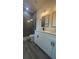 Beautiful bathroom with modern lighting, gray shower and tile, and white cabinets at 16367 Sw 17Th Terrace Rd, Ocala, FL 34473