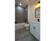 Modern bathroom featuring gray tiled shower with a white vanity, black fixtures and wood look floor at 16367 Sw 17Th Terrace Rd, Ocala, FL 34473