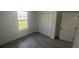 Clean bedroom with window, closet, gray floors, and white walls at 16367 Sw 17Th Terrace Rd, Ocala, FL 34473