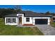 Charming single-Gathering home boasts a modern design with a brick-paved driveway and a black two-car garage at 16367 Sw 17Th Terrace Rd, Ocala, FL 34473