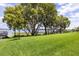Lush green lawn with mature trees and a waterfront view at 16761 Broadwater Ave, Winter Garden, FL 34787