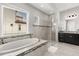 Bright bathroom featuring a soaking tub, glass-enclosed shower, and modern finishes, perfect for relaxation at 16761 Broadwater Ave, Winter Garden, FL 34787
