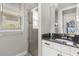 Bathroom featuring a granite countertop vanity, shower with glass door, and a large window at 16761 Broadwater Ave, Winter Garden, FL 34787