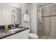Bathroom featuring granite countertop, gray tile shower with glass door, and modern fixtures at 16761 Broadwater Ave, Winter Garden, FL 34787