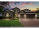 Charming stone home featuring a three-car garage, brick paver driveway and lush landscaping at 16761 Broadwater Ave, Winter Garden, FL 34787