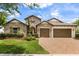 Charming stone home featuring a three-car garage, brick paver driveway and lush landscaping at 16761 Broadwater Ave, Winter Garden, FL 34787
