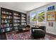 Inviting living room with a large bookshelf, plush seating, and a colorful area rug at 16761 Broadwater Ave, Winter Garden, FL 34787