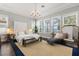 Bright main bedroom featuring large windows, an elegant chandelier, and a cozy chaise lounge, offering lake views at 16761 Broadwater Ave, Winter Garden, FL 34787