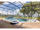 Screened-in pool area with a spa, fire pit, and lake view at 16761 Broadwater Ave, Winter Garden, FL 34787