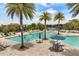 Beautiful community pool with palm trees, lounge chairs, and stunning views of the surrounding landscape at 16761 Broadwater Ave, Winter Garden, FL 34787