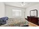 Bright bedroom with light hardwood floors, floral bedding, and a dresser with mirror at 1705 Virginia Dr, Orlando, FL 32803
