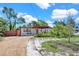 Charming single-story home with a gravel driveway and covered carport, showcasing its inviting curb appeal at 1705 Virginia Dr, Orlando, FL 32803