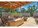 Covered outdoor patio with furniture, a ceiling fan, stone fountain, and surrounding greenery at 1705 Virginia Dr, Orlando, FL 32803