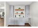 Stylish bar area with gray cabinetry, wooden shelves, tile backsplash, and modern countertops at 17524 Seidner Rd, Winter Garden, FL 34787