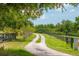 Scenic driveway winding through lush greenery, bordered by a classic black fence at 17524 Seidner Rd, Winter Garden, FL 34787