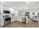 Modern kitchen with white cabinets, stainless steel appliances, and open layout to dining area at 17524 Seidner Rd, Winter Garden, FL 34787