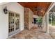 Back patio with brick outdoor grill, flagstone flooring, wooden ceiling, and access to screened-in porch at 17524 Seidner Rd, Winter Garden, FL 34787