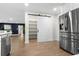 Kitchen view with a sliding barn door to a pantry closet and a stainless steel refrigerator at 17524 Seidner Rd, Winter Garden, FL 34787