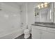 Well-lit bathroom with granite countertop, white cabinets, and shower-tub combo at 17537 Sailfin Dr, Orlando, FL 32820