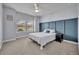 Cozy bedroom with a stylish blue accent wall, plush carpet, and ample natural light at 17537 Sailfin Dr, Orlando, FL 32820