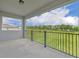 Covered lanai with black metal railing, offering serene views of the expansive green backyard at 17537 Sailfin Dr, Orlando, FL 32820