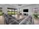 Comfortable living room with sliding glass doors to backyard, sleek wood floors, and modern entertainment setup at 17537 Sailfin Dr, Orlando, FL 32820